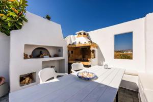 a dining room with a table and chairs and a fireplace at Agnanti Studios in Naousa