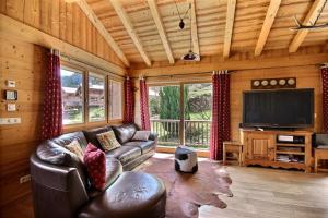 un salon avec un canapé et une télévision à écran plat dans l'établissement CHALET SAUNA AU PIED DES PISTES - SAINT JEAN D'AULPS STATION - 14 PERSONNES - CHALET PHOENIX, à Saint-Jean-dʼAulps