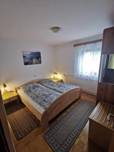 Un dormitorio con una cama grande y una ventana en Apartments Štros, en Bohinj
