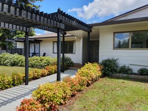a house with a pergola in a yard at Kerikeri Central House in Kerikeri