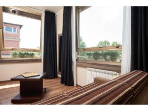 ein Wohnzimmer mit einem Bett und einem großen Fenster in der Unterkunft Window On Rome in Rom