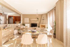 een eetkamer en een woonkamer met een tafel en stoelen bij MiLo Luxury House -Free Airport pick up-10min drive in Markopoulon