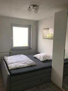 a small bedroom with a bed with a window at Haus Mozartstraße in Mutlangen