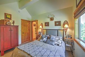 a bedroom with a bed and a red cabinet at Bright Klamath Falls Cabin with Deck and Mtn Views! in Klamath Falls