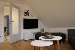 a living room with a couch and a table and a tv at CASA STROBL in Landsberg am Lech