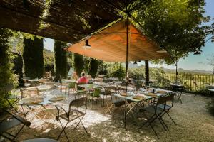 a group of tables and chairs under an umbrella at La Treille Muscate in Cliousclat