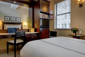 a hotel room with a bed and a desk with a computer at Library Hotel by Library Hotel Collection in New York