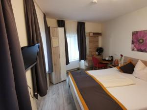 um quarto de hotel com uma cama e uma televisão em Garni City Hotel em Füssen