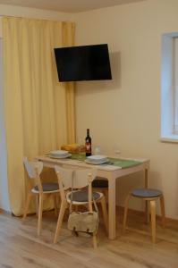 a dining room table with a bottle of wine and chairs at Apartman Masaryk in Lipova Lazne