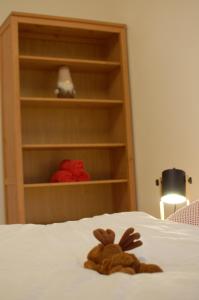 a stuffed animal sitting on top of a bed at Apartman Masaryk in Lipova Lazne