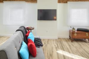 sala de estar con sofá gris y almohadas coloridas en Casa Del Carmen IIII - Parking incluido, en Tudela