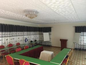 una sala de conferencias con mesas, sillas y una lámpara de araña en Dream Palace Hotel Mbale en Mbale