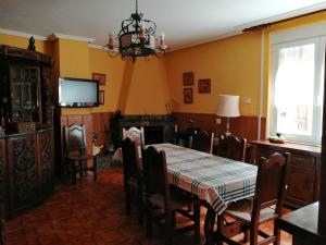 a dining room with a table and a tv at Casa Rural El Capricho del Tejar in Cimanes del Tejar