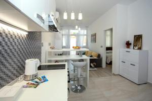 a kitchen with white cabinets and a counter top at Sibenik city center Apartment Sonia in Šibenik
