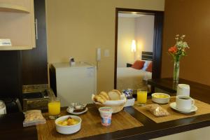 una cocina con una mesa con productos para el desayuno y zumo de naranja en Hotel Ankara Suites en Salta