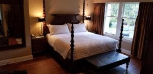 Schlafzimmer mit einem Bett und einem großen Fenster in der Unterkunft Crown Mansion Boutique Hotel & Villas in Qualicum Beach