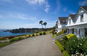 a white house with a driveway next to the water at Little River Inn in Little River