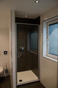 a glass shower in a bathroom with a window at Hotel Restaurant Lamm in Mönsheim