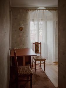 a dining room with a table and two chairs and a window at Prut in Yaremche
