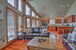 a living room with leather couches and a kitchen at Fairplay House with Deck and Panoramic Nature Views! in Fairplay