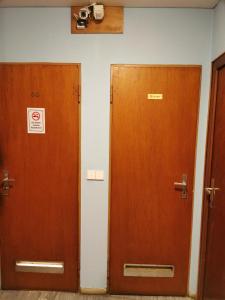 zwei Holztüren in einem Raum mit einer Kamera an der Wand in der Unterkunft See Lord Hotel in Kaiserslautern