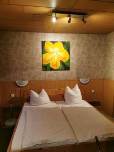 a bed in a room with a yellow flower on the wall at See Lord Hotel in Kaiserslautern +16 photos