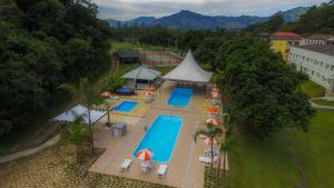 una vista aérea de una piscina con sombrillas y mesas en Hotel Termas da Guarda, en Tubarão