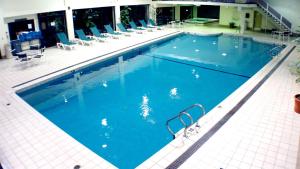 a large swimming pool with blue water in a building at The Margate Resort in Laconia