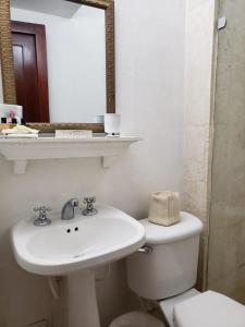 a bathroom with a sink and a toilet and a mirror at Casa Cordoba Román in Cartagena de Indias
