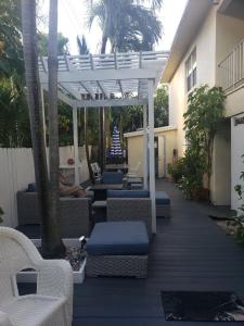 a patio with wicker chairs and a pergola at Ashley Brooke Beach Resort in Deerfield Beach