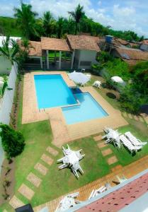 uma vista sobre uma piscina com espreguiçadeiras e um quintal em Pousada Portal do Prado em Prado