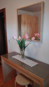 een vaas met bloemen op een tafel voor een spiegel bij Ferienwohnung Wohlesser in Annaberg im Lammertal