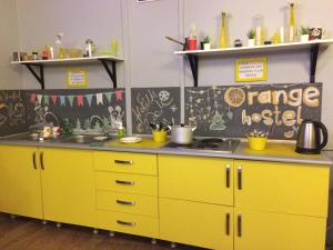 a kitchen with yellow cabinets and a sink at Orange Hostel in Rostov on Don