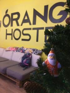 a christmas tree with a couch in front of a sign at Orange Hostel in Rostov on Don