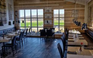 a dining room with tables and chairs and windows at Hraunsnef Country Hotel in Bifrost