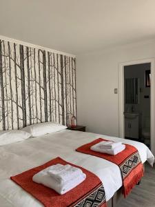 una camera da letto con due asciugamani su un letto di Rumbo Suites a Punta Arenas
