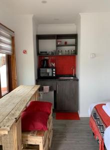 a room with a wooden table and a kitchen at Rumbo Suites in Punta Arenas