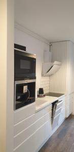 eine Küche mit weißen Schränken und einer Arbeitsplatte in der Unterkunft Commodores Quarters in Braşov