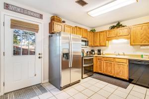 a kitchen with wooden cabinets and a stainless steel refrigerator at Woodland Shores in Destin