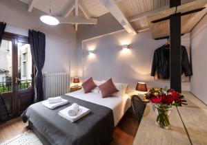 a hotel room with a bed and a vase of flowers at White Hills Suites & Spa in Arachova