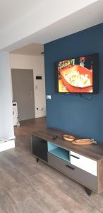 ein Wohnzimmer mit einem Fernseher an einer blauen Wand in der Unterkunft Commodores Quarters in Braşov