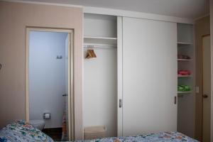 a bedroom with a door to a closet and a bed at Departamento 100 m2 con luz natural Seguridad 24h in Lima +11 photos