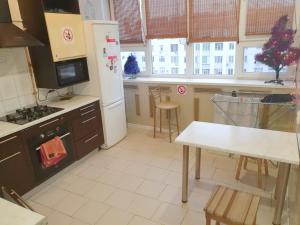 a kitchen with a refrigerator and a table in it at Kharkov CITIZEN in Kharkiv