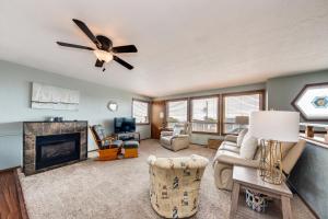a living room with a ceiling fan and a fireplace at Sea Breeze in Lincoln City