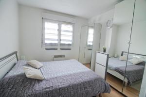 a white bedroom with two beds and a mirror at DESIGN APARTMENT Near GENEVA in Étrembières