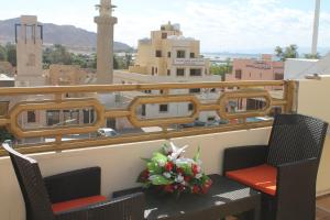 a balcony with two chairs and a bouquet of flowers at Relax House For Studio Rooms Apartment in Aqaba