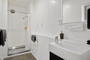 un bagno bianco con lavandino e doccia di Central Gateway Motel a Cromwell