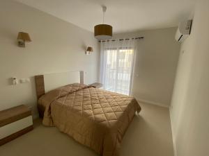 a bedroom with a bed and a window at Albur Village B - Lotus in Alvor +13 photos
