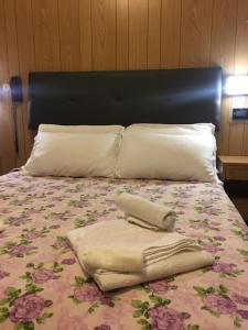 Hotel Giordano Spiaggia في ريميني: سرير عليه بطانيه ووسادتين