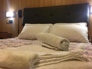 una camera da letto con un letto e asciugamani di Hotel Giordano Spiaggia a Rimini